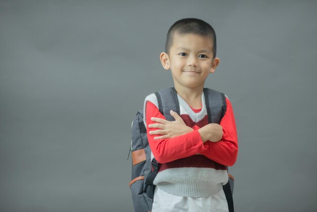 Regreso a la escuela Longitud total de un niño divertido de 6 años en una mochila con libros escolares Niño de la escuela primaria con un libro y una bolsa Educación