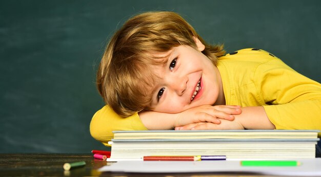 Regreso a la escuela y tiempo feliz El niño está aprendiendo en clase en el fondo de la pizarra Niño sonriente alegre en la pizarra