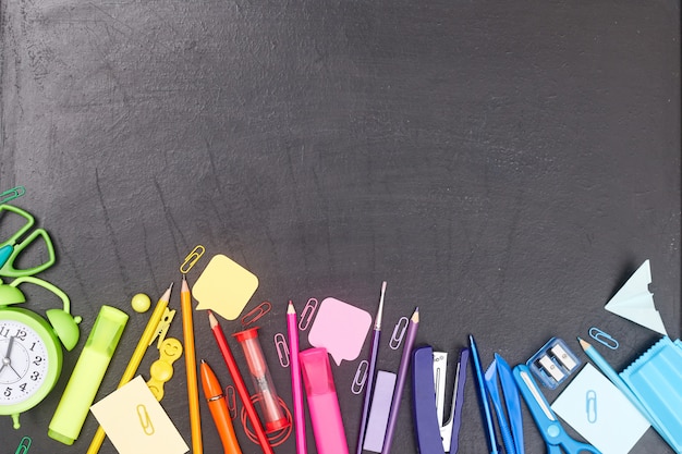 Foto regreso a la escuela, útiles escolares multicolores, arco iris en la junta escolar, flatlay, copyspace