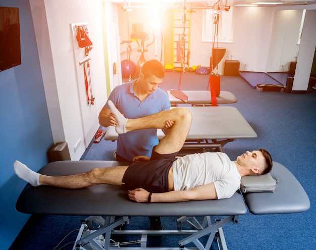 Rehabilitationstherapie. Physiotherapeut arbeitet mit jungen männlichen Patienten