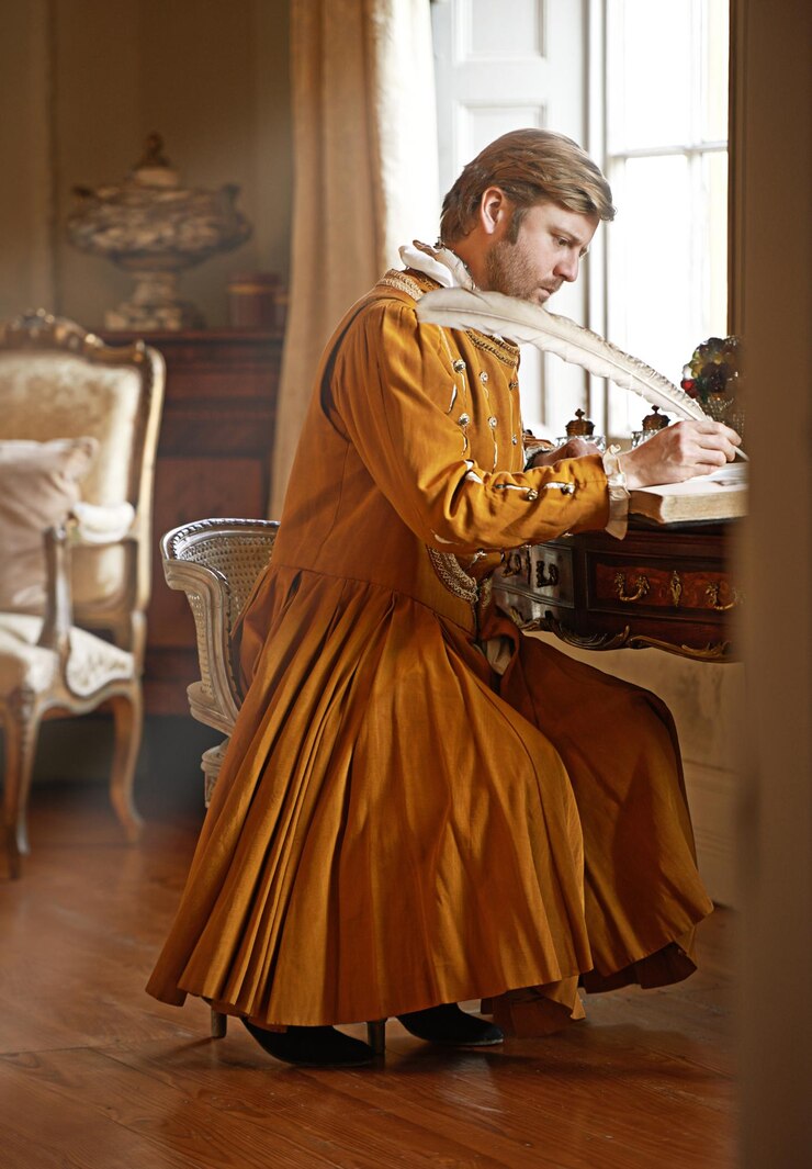 Foto rei medieval e escrita com pena em livro para renascimento realeza estética ou carta no quarto do palácio monarca pessoa rica e roupas elegantes para cosplay real ou comunicação no castelo
