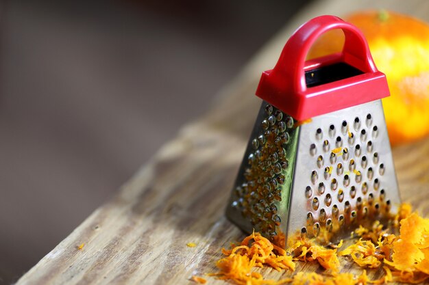 Reibeschale von Zitrusfrüchten und auf dem Holztisch