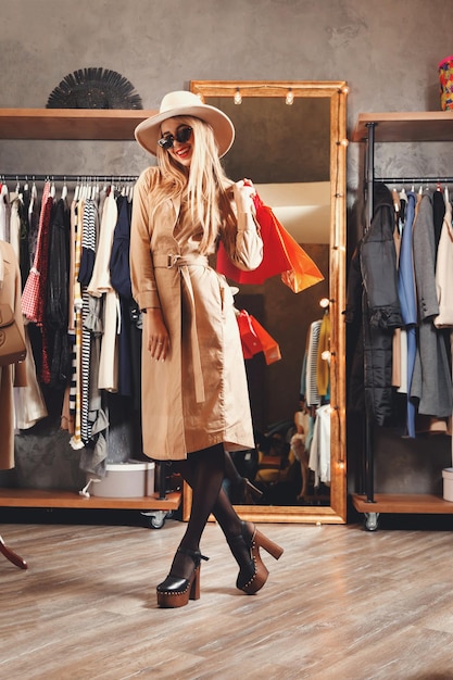 Reiche, hübsche, blonde Shopaholic-Frau mit Sonnenbrille und Modehut genießen das Einkaufen im Fashion-Mall-Konzept des Konsums Black Friday Sale Rich Life