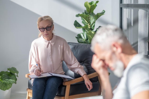 Reife Amn sieht gestresst aus, während sie sich mit einem Psychologen unterhält