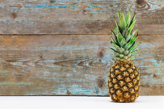 Reife Ananas auf einem weißen Holztisch mit Kopierraum