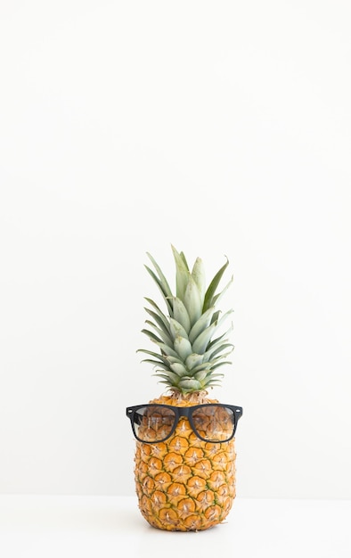 Foto reife ananas in sonnenbrillen auf weißem hintergrund sommerurlaub hallo sommer