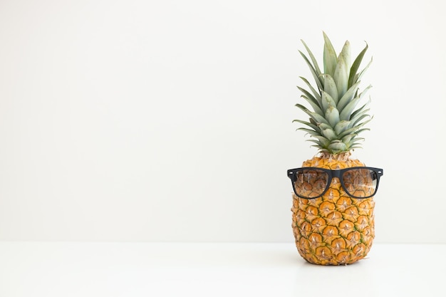 Reife Ananas in Sonnenbrillen auf weißem Hintergrund Sommerurlaub Hallo Sommer