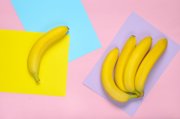 Reife Bananen auf einer farbigen Papierwand. Pastellfarbentrend. Das Konzept der Einzigartigkeit. Minimalismus, Draufsicht