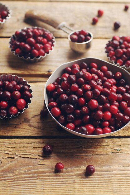 Reife Bio-Cranberry auf rustikalen Holztisch frischen Beeren in Schüsseln Herbsterntekonzept