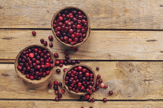 Reife Bio-Cranberry auf rustikalen Holztisch frischen Beeren in Schüsseln Herbsterntekonzept