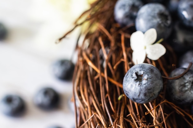 Reife Blaubeeren Blaubeeren befinden sich in einem Weinkorb mit Hortensienblüten in der Nähe