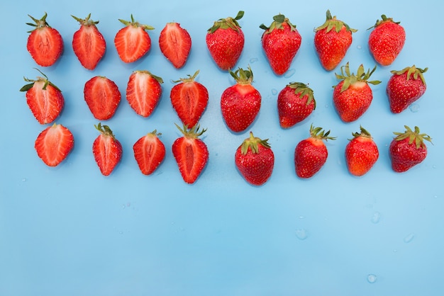 Reife Erdbeeren auf einer blauen Oberfläche.