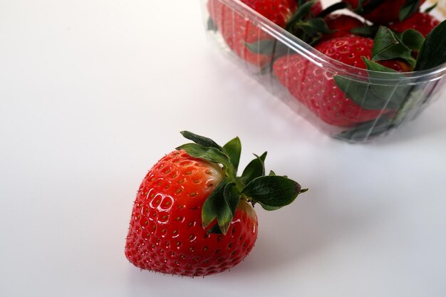 Reife Erdbeeren in einer Plastikverpackung auf weißem Hintergrund Köstliche frische Beeren in einem Behälter