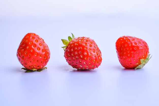 reife Erdbeeren lokalisiert auf weißem Hintergrund mit einer Reflexion einer Nahaufnahme