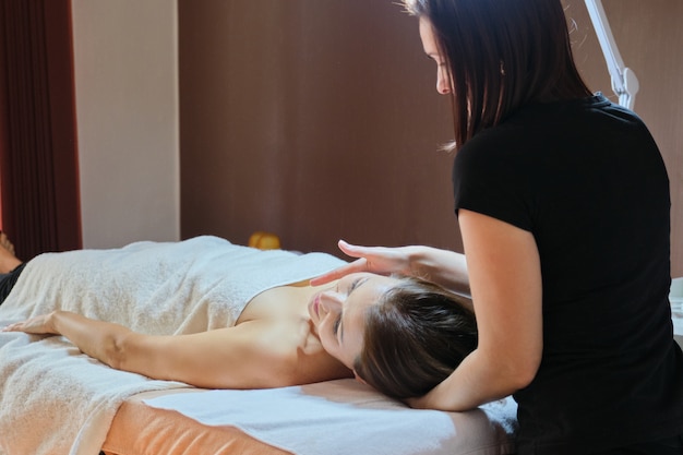 Reife Frau, die auf Massagetisch liegt und medizinische Massage erhält