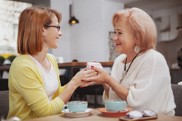 Reife Frau, die ihre ältere Mutter im Café trifft