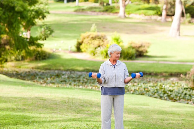 Reife Frau, die ihre Übungen im Park tut