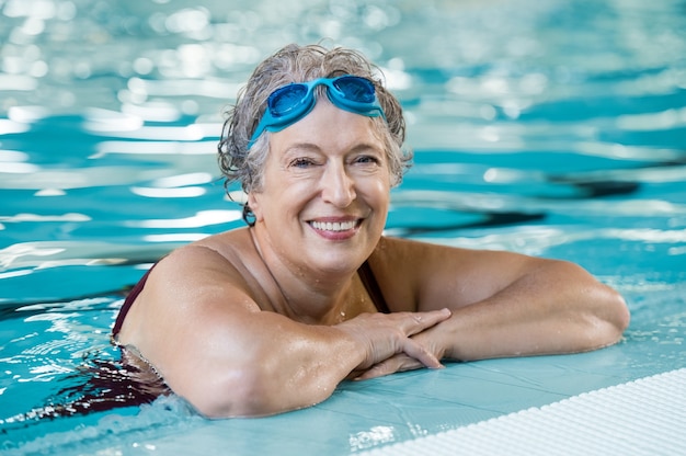 Foto reife frau, die schwimmbrille im schwimmbad trägt