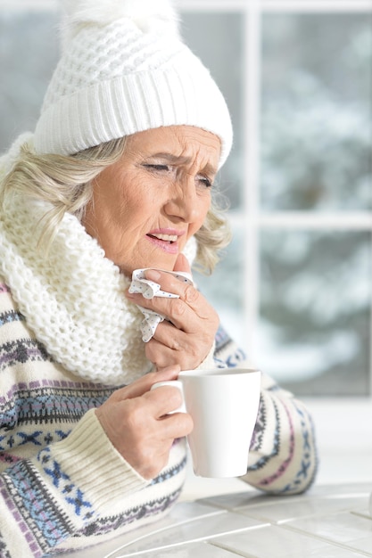 Reife Frau fühlt sich schlecht im Café sitzen