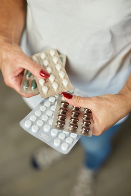 Reife Frau hält Blisterpackung Pillen in der Hand