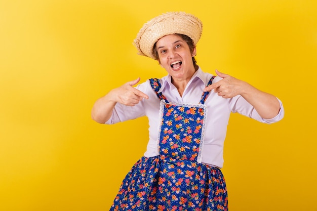 Reife Frau in typischer Kleidung von Festa Junina Einladendes Schild hier nur hier ist hier