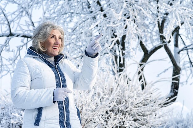 Reife Frau in Winterkleidung posiert im Freien, gut gelaunt