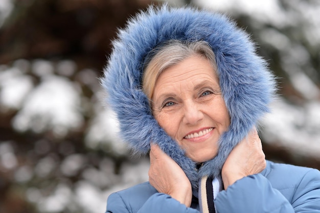 Reife Frau in Winterkleidung posiert im Freien, gut gelaunt