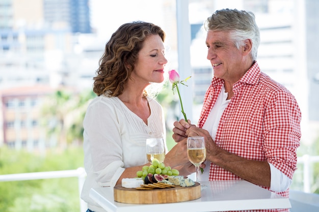 Reife Frau mit Mann, der Blume riecht