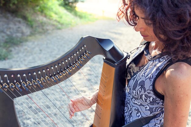 Foto reife frau spielt harfe im freien