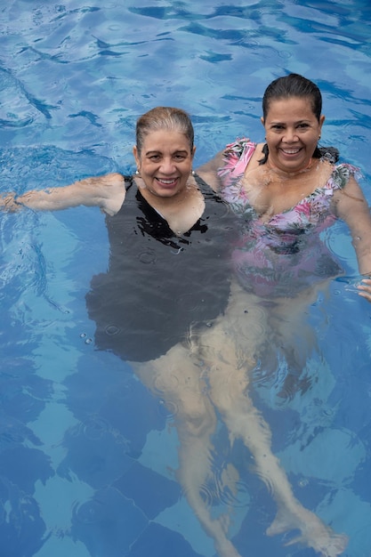 Reife Frauen entspannen am Pool in der Sonne