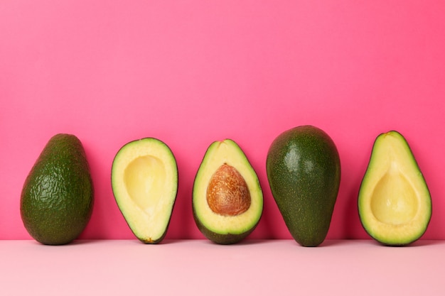 Reife frische Avocado auf rosa Hintergrund, Platz für Text