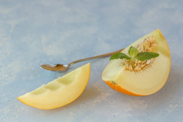 Reife frische gelbe Melone in Stücke geschnitten auf blau