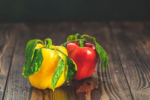 Reife, frische, süße rote und gelbe Bio-Paprika auf dunklem Holztisch. Auswahl an gesunden Lebensmitteln für das Herzlebenskonzept