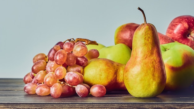 Reife Früchte, Äpfel, Birnen Trauben auf einem alten Holztisch. Obststillleben