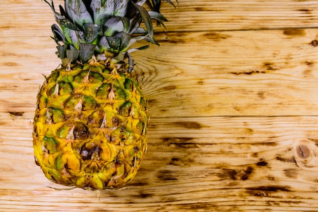 Reife ganze Ananas auf rustikalem Holztisch. Ansicht von oben