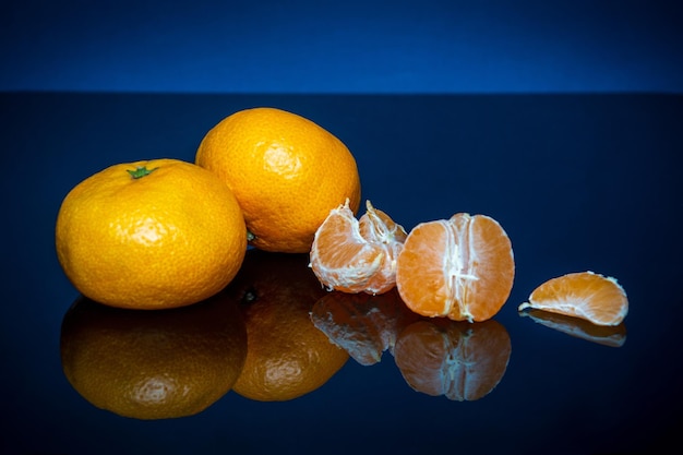 Reife gelbe Mandarinen oder Mandarinenfrüchte auf blauem Hintergrund Idee Clementinen Dieta