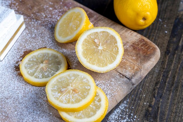 Reife gelbe Zitrone in Stücke geschnitten auf einem Schneidebrett Saftige gelbe Zitrone auf einem Schneidebrett während des Kochens