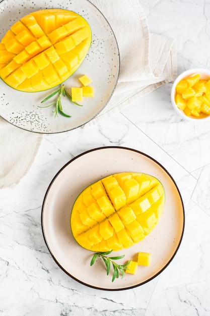 Reife geschnittene Mangos auf Tellern auf dem Tisch Tropische Früchte Top und vertikale Ansicht