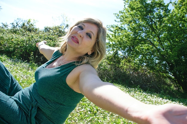 Reife glückliche Frau im Gras mit Margeriten Menopause und Muttertagskonzept