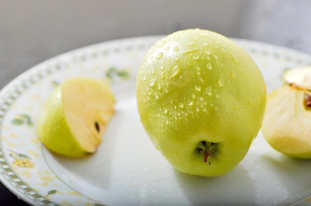 Reife goldene Äpfel mit Wassertropfen darauf auf dunklem Hintergrund