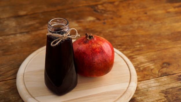 Reife Granatäpfel mit Saft auf hölzernem Hintergrund