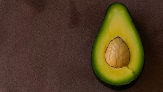 Reife grüne Avocado auf lila Hintergrund