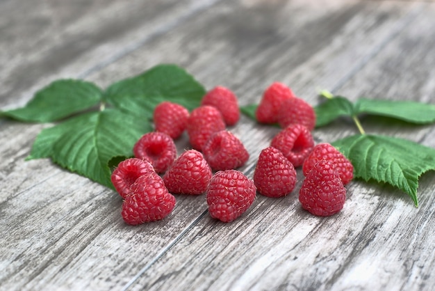 Reife Himbeeren auf einem hölzernen Hintergrund.