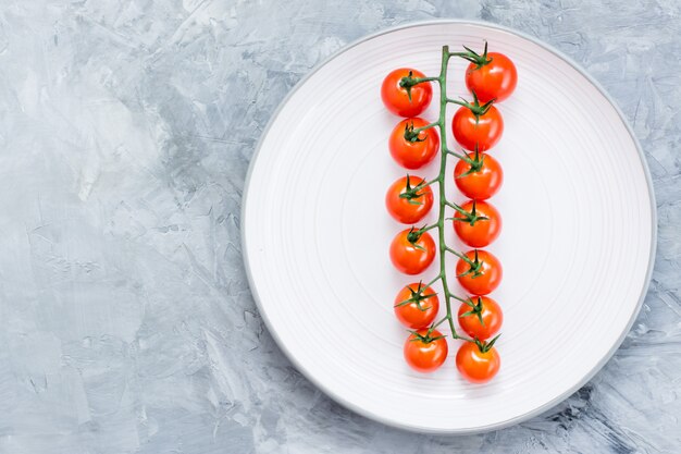 Reife Honigkirschtomaten auf einer Niederlassung auf einer Platte auf Beton