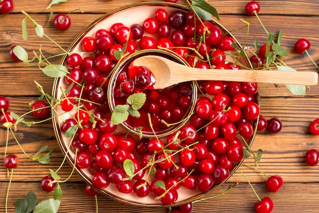 Reife Kirschen auf einem Holzplatt Ernte von roten Beeren auf einem hölzernen Hintergrund