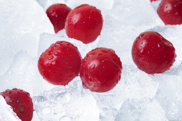 Reife Kirschen bedeckt mit Tropfen auf Eiswürfeln hautnah