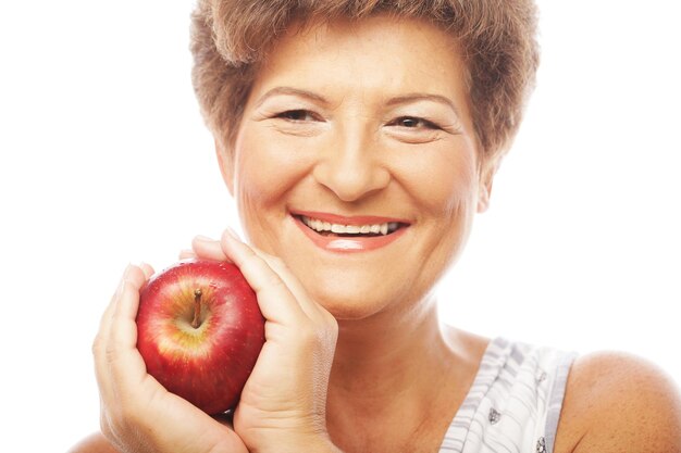 Reife lächelnde Frau mit Apfel