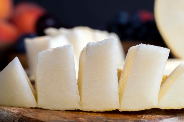 Reife, leckere Melone während des Desserts, leichte und saftige Melone auf einem Holztisch während des Schneidens