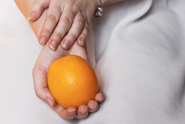 Reife leuchtende Orange in zarten weiblichen Händen