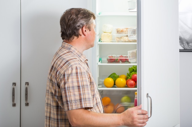 Foto reife männer am kühlschrank mit essen